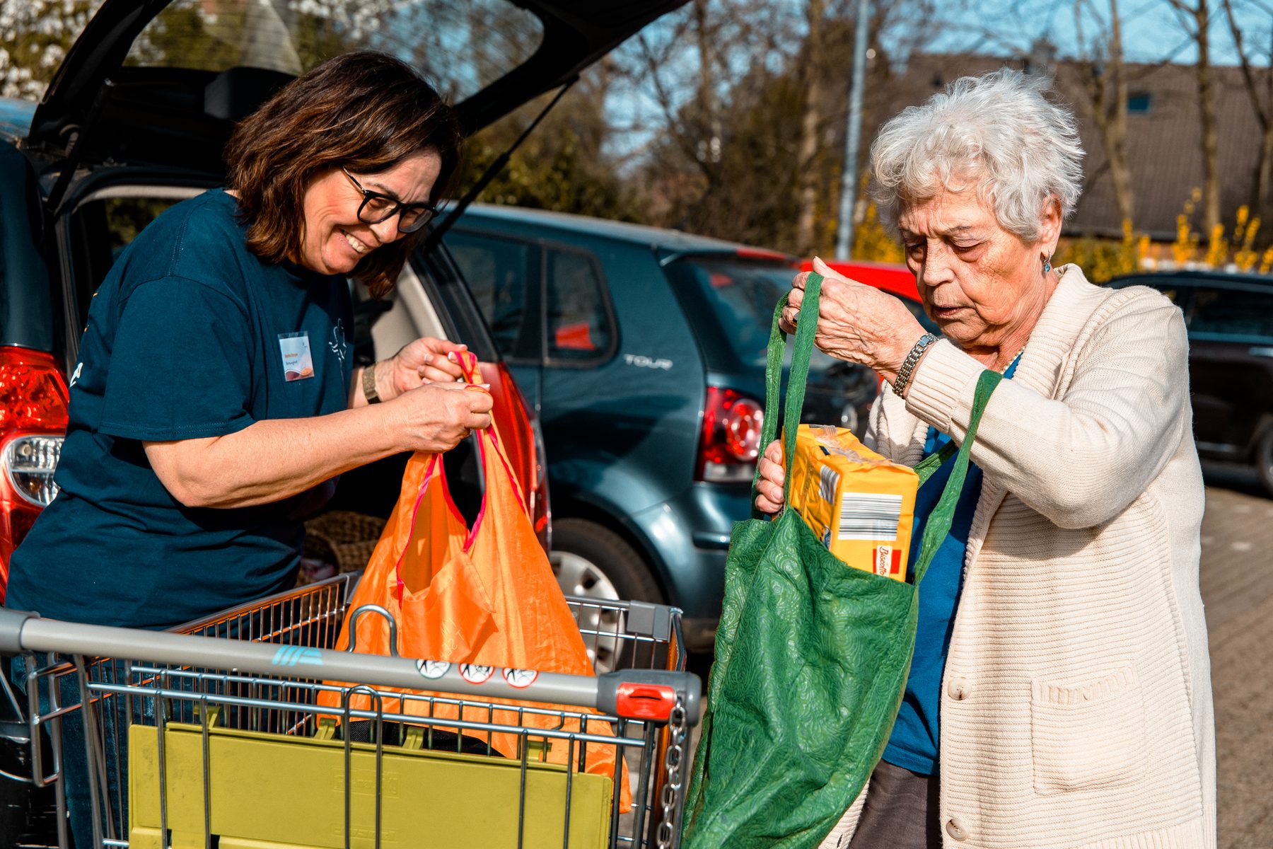 Betreuungskraft hilft beim Einpacken des Einkaufs